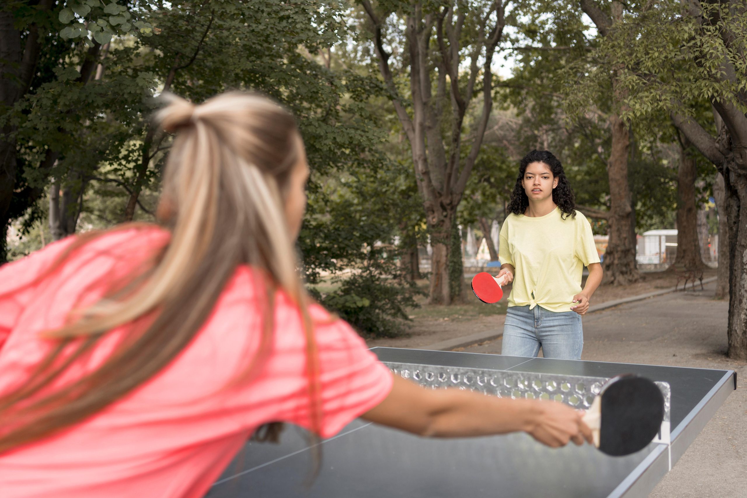 chicas de tiro medio jugando tenis de mesa